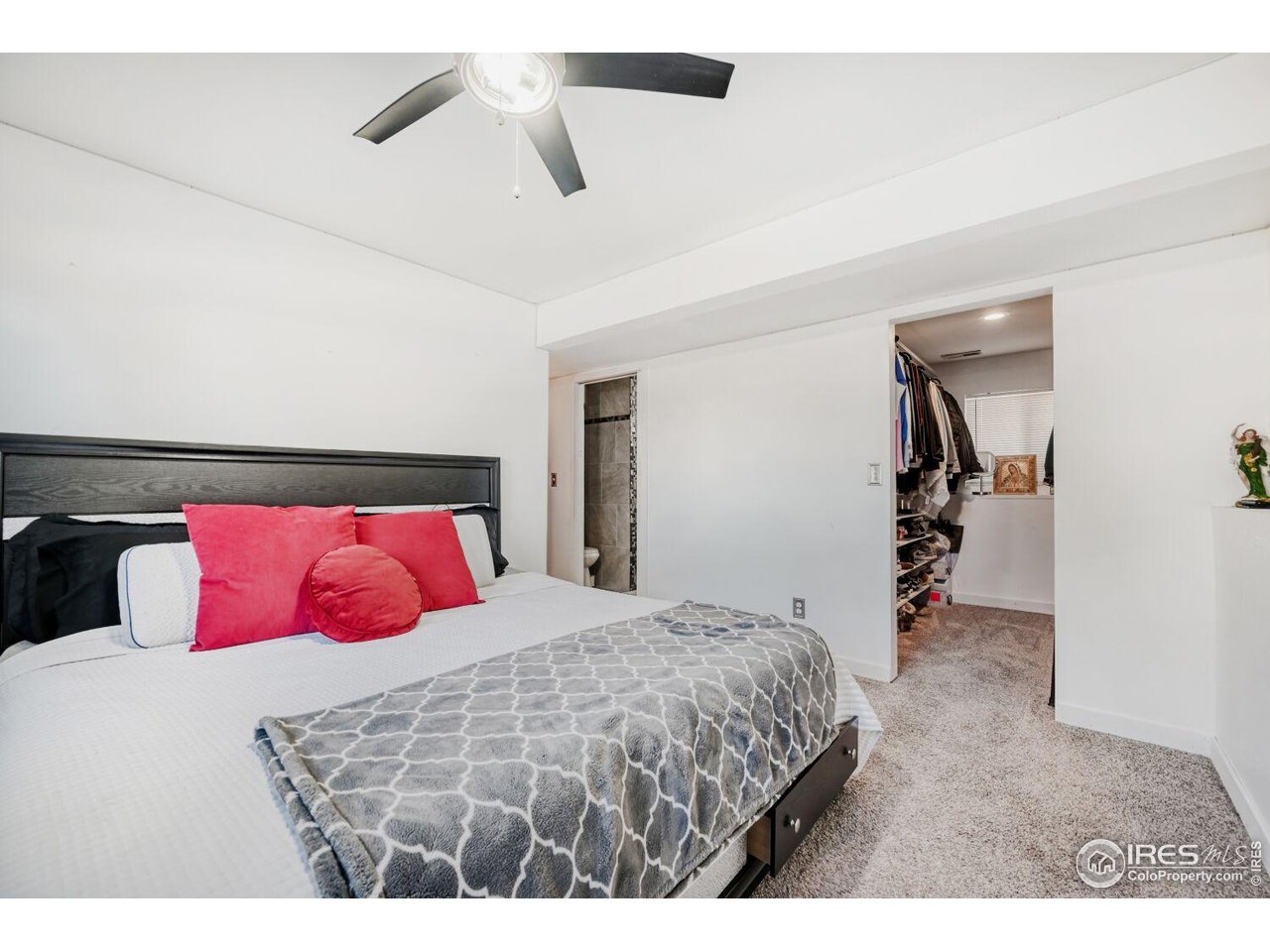 223 Fifth Street Firestone, CO 80520 - Photo 17 of 27 a bedroom with a large bed and a chandelier