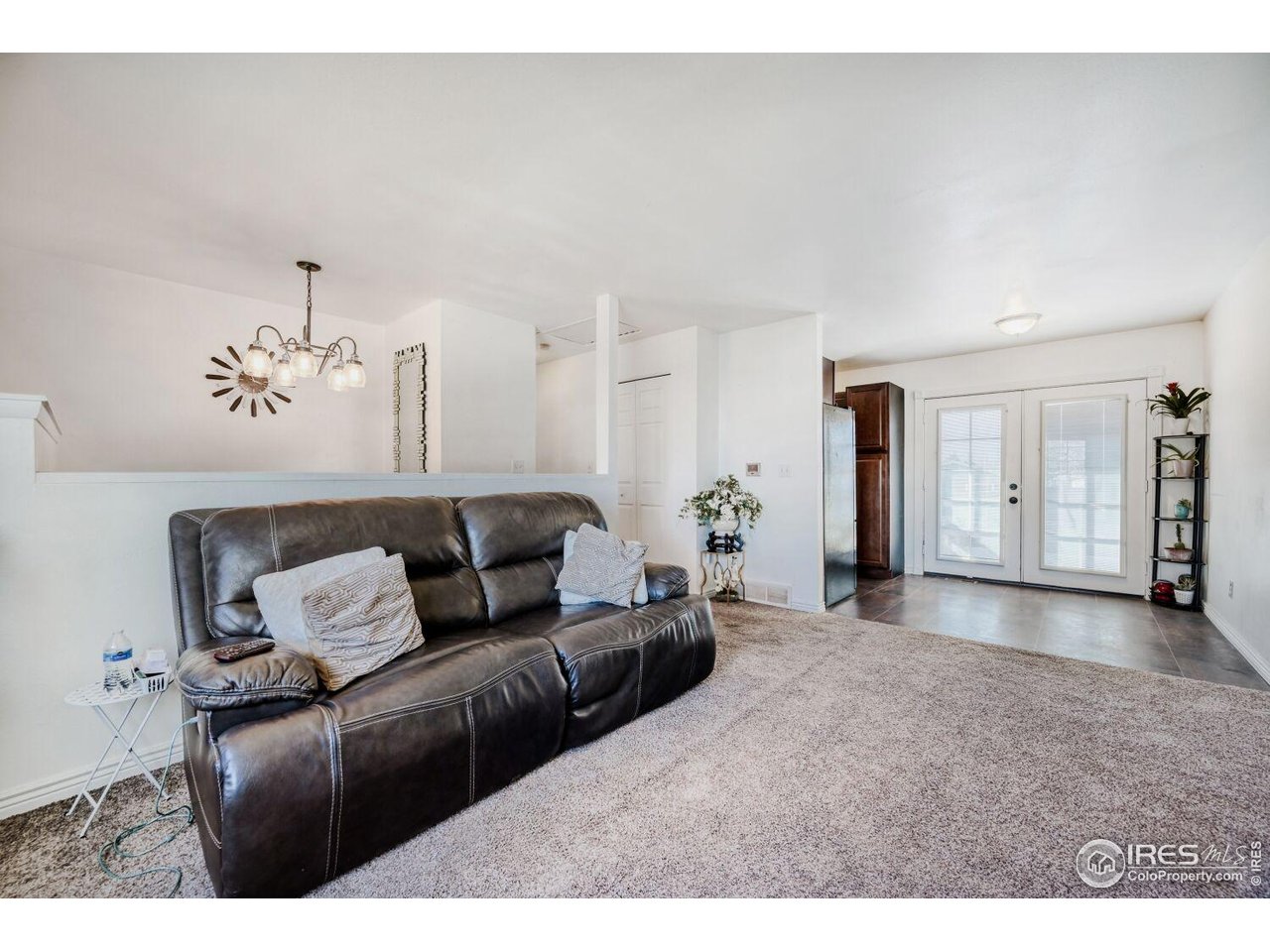 223 Fifth Street Firestone, CO 80520 - Photo 6 of 27 a living room with furniture and a chandelier