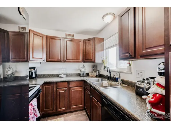 a kitchen with a sink dishwasher and cabinets with wooden floor