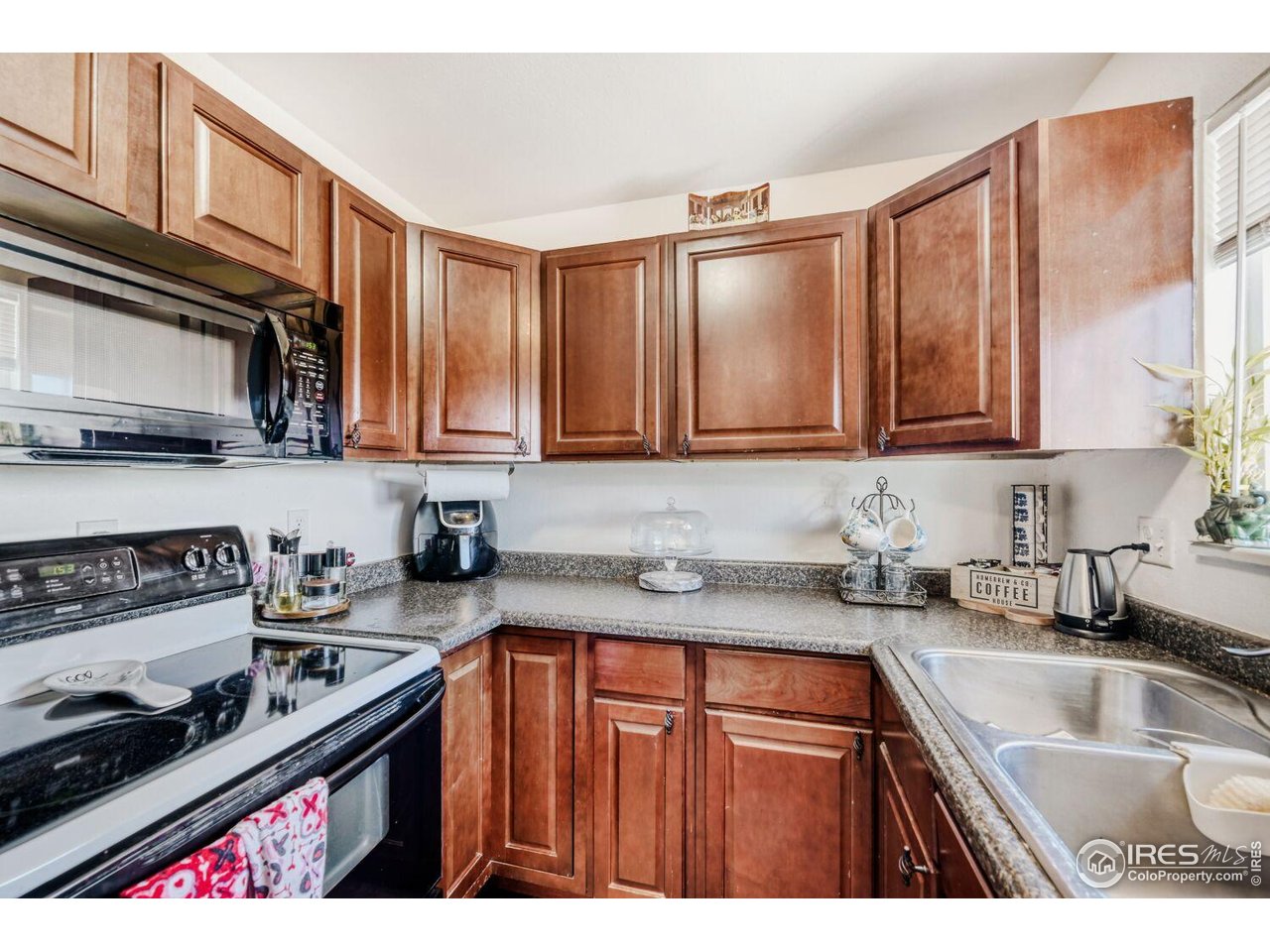 223 Fifth Street Firestone, CO 80520 - Photo 10 of 27 a kitchen with stainless steel appliances granite countertop a sink stove and microwave