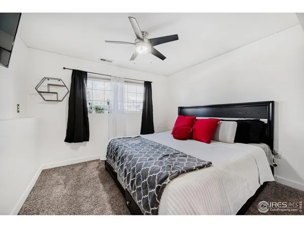 a bedroom with a bed and a ceiling fan