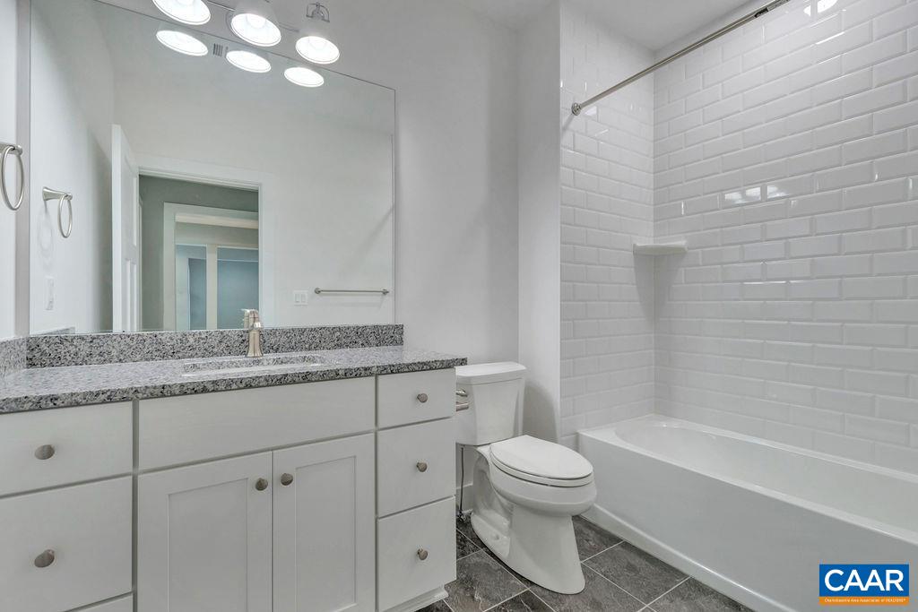 3 B Rothwell Lane, Unit LOT 3B Crozet, VA 22932 - Photo 19 of 29 a bathroom with a granite countertop toilet a sink and a bathtub