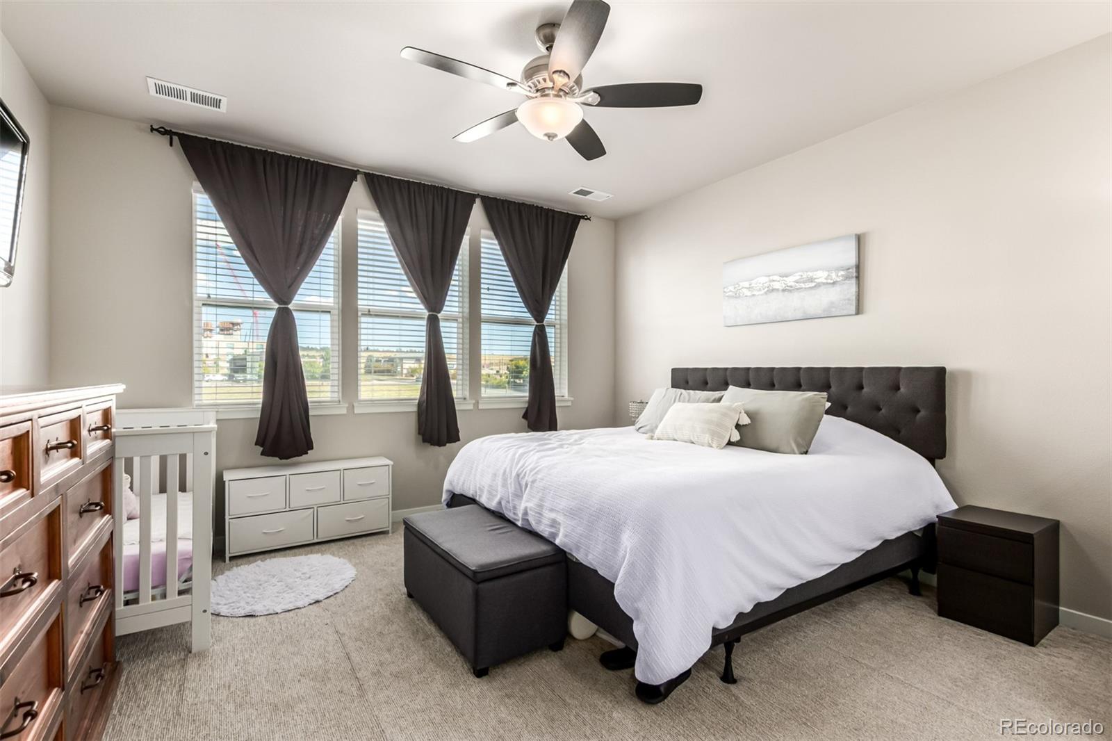 9287 Twenty Mile Road, Unit 204 Parker, CO 80134 - Photo 11 of 30 a bedroom with a large bed large window with a bed and a couch