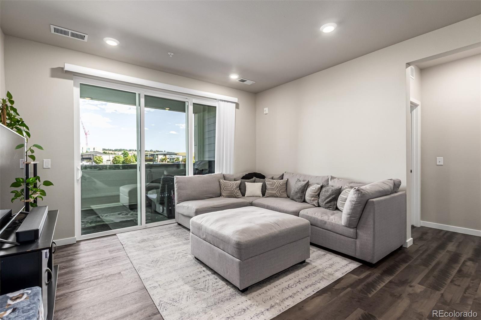 9287 Twenty Mile Road, Unit 204 Parker, CO 80134 - Photo 3 of 30 a living room with furniture and a floor to ceiling window
