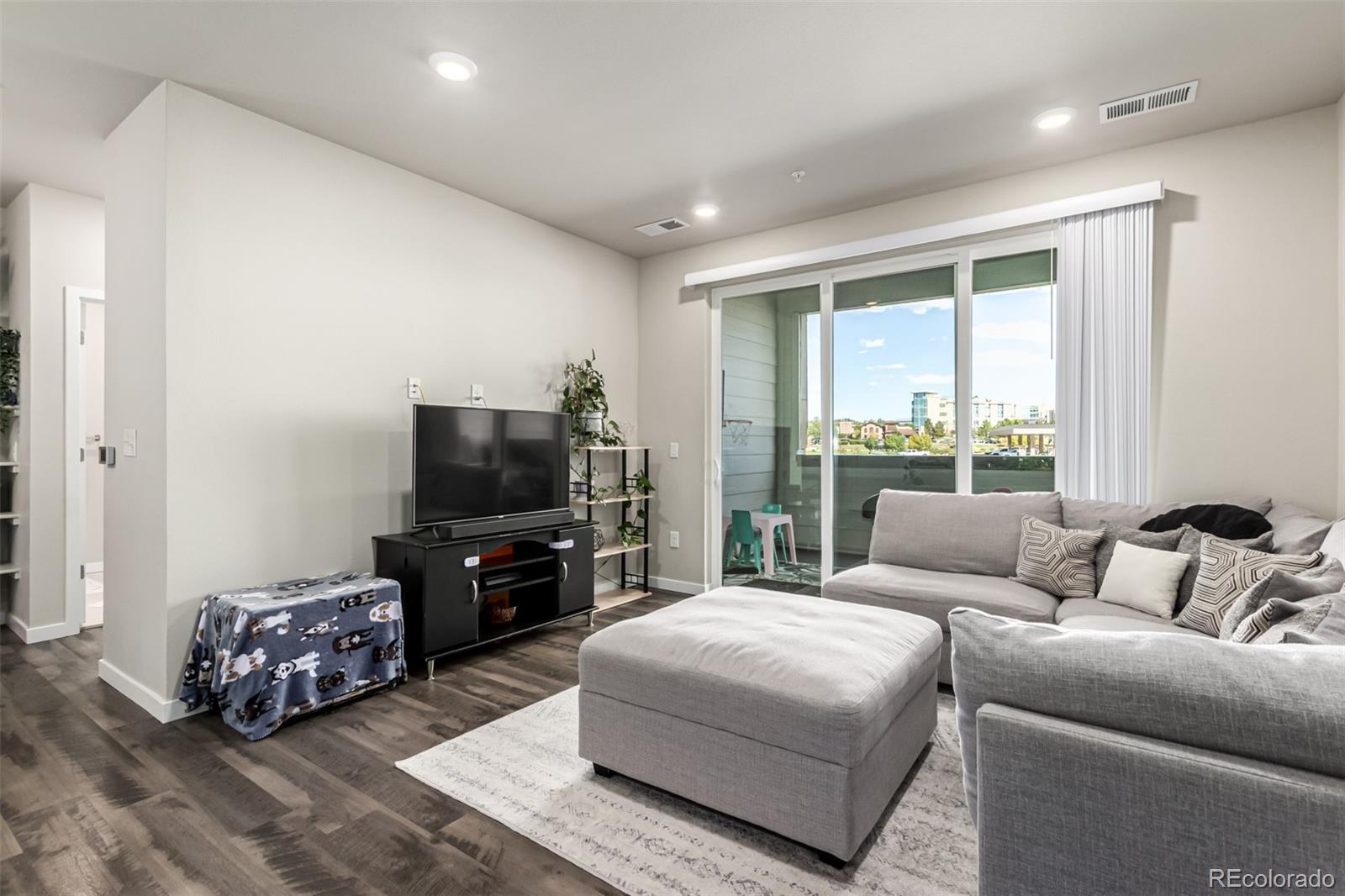 9287 Twenty Mile Road, Unit 204 Parker, CO 80134 - Photo 5 of 30 a living room with furniture and a flat screen tv