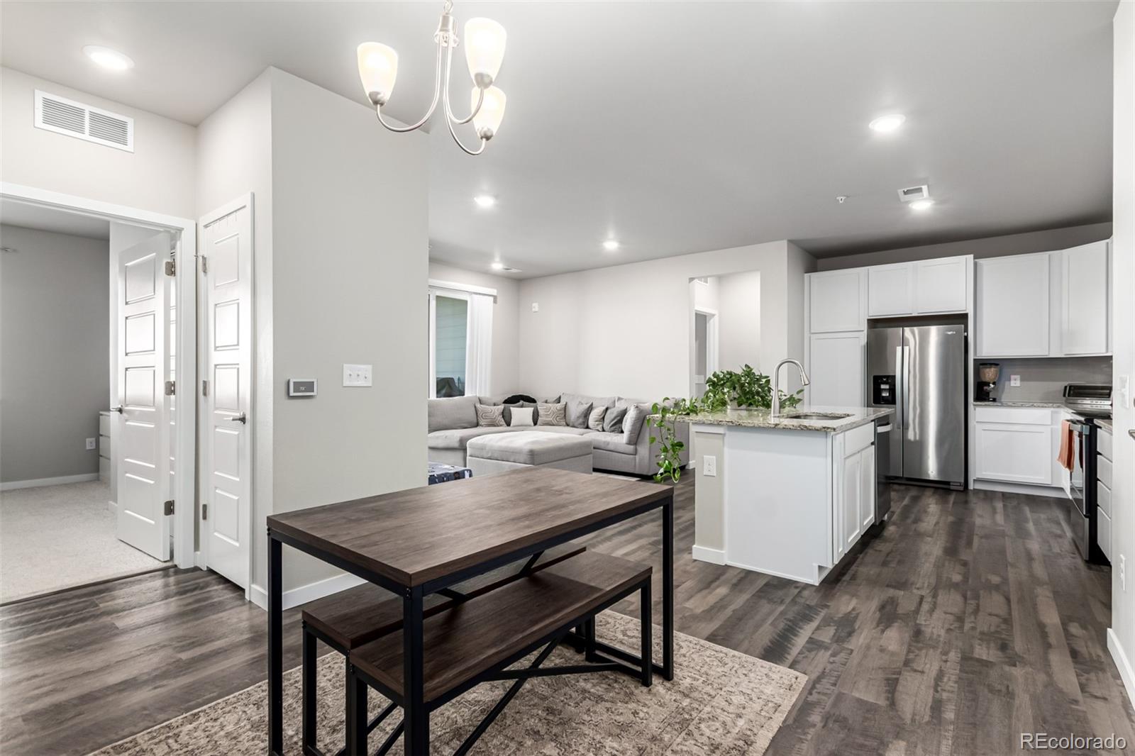 9287 Twenty Mile Road, Unit 204 Parker, CO 80134 - Photo 7 of 30 a kitchen with a table chairs refrigerator and wooden cabinets