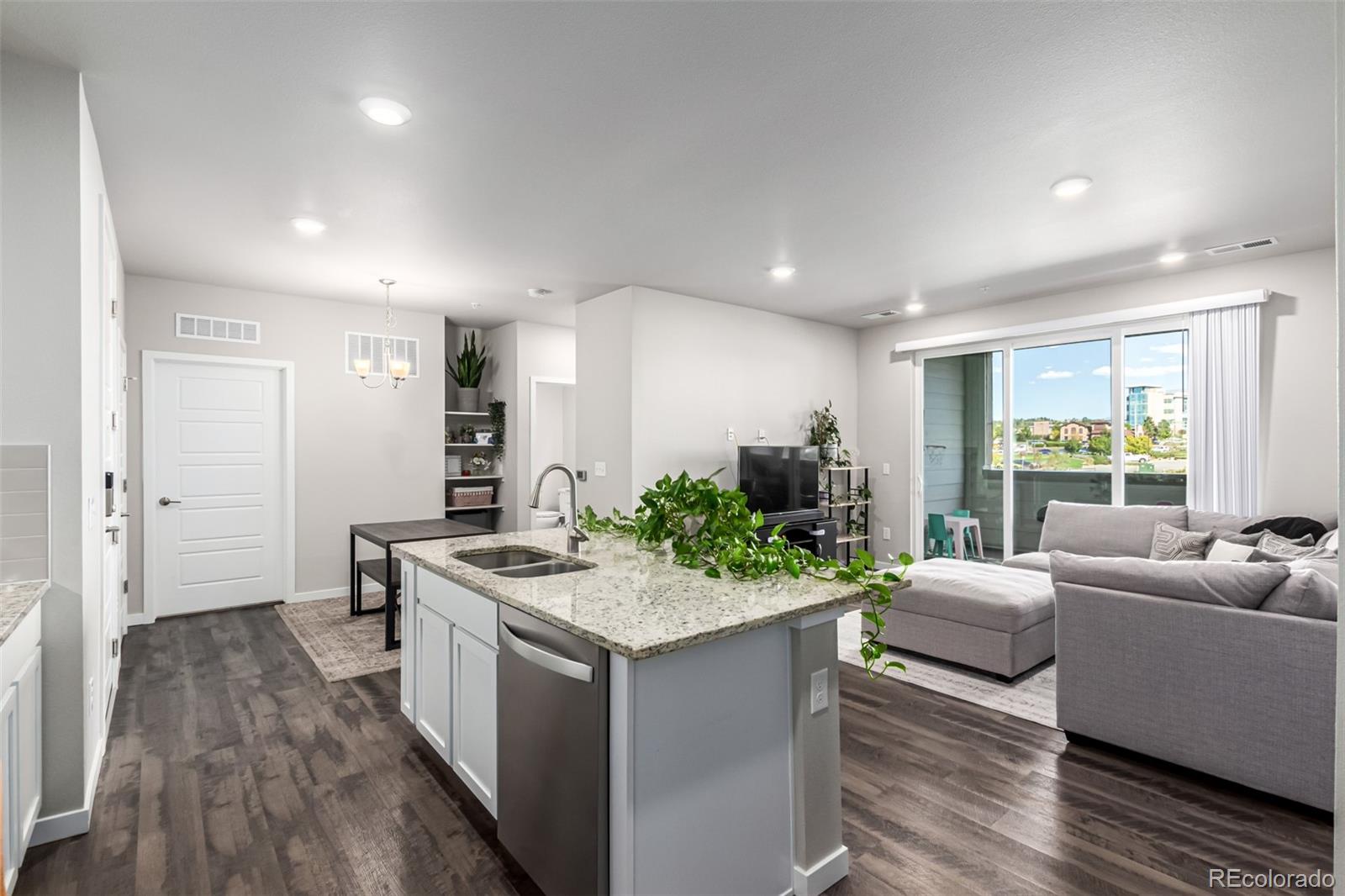 9287 Twenty Mile Road, Unit 204 Parker, CO 80134 - Photo 10 of 30 a open kitchen with stainless steel appliances granite countertop a lot of counter space and wooden floor