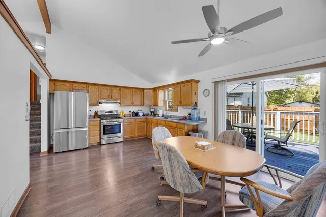 a dining room with furniture a kitchen view and a large window