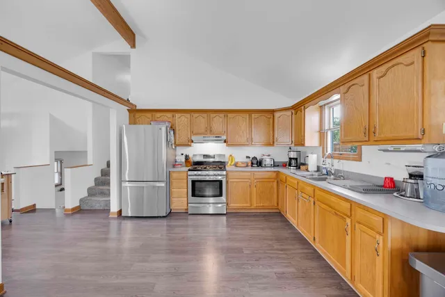 a kitchen with sink a refrigerator and white cabinets