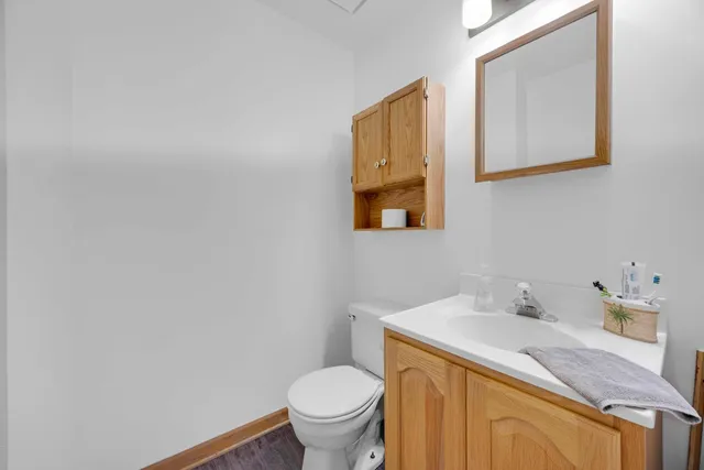 a bathroom with a granite countertop sink mirror vanity and toilet