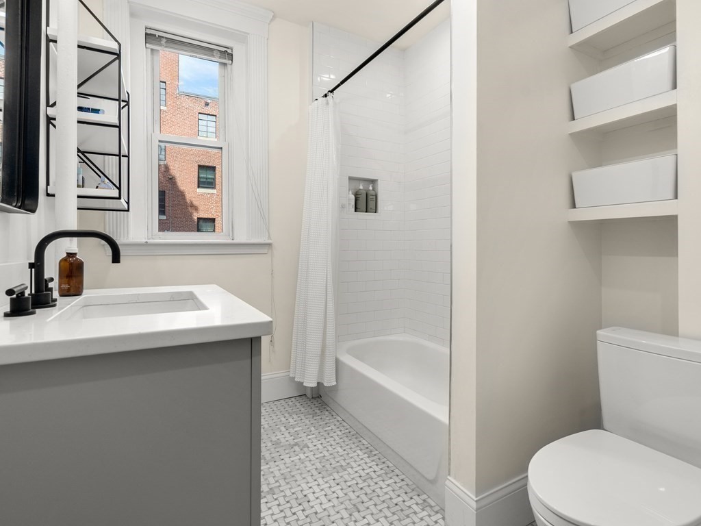 640 Washington Street, Unit 1 Brookline, MA 02446 - Photo 13 of 18 a bathroom with a sink toilet and shower