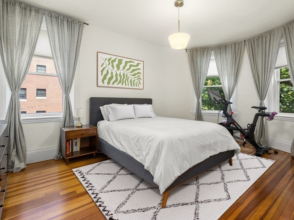 640 Washington Street, Unit 1 Brookline, MA 02446 - Photo 8 of 18 a bedroom with a bed and a dresser next to a window