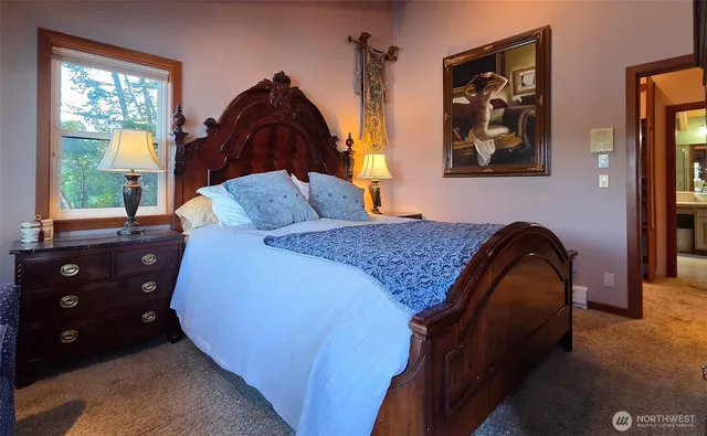 a bedroom with a bed and a painting on the wall