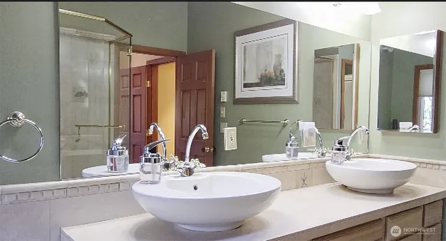 a bathroom with a double vanity sink mirror and bathtub