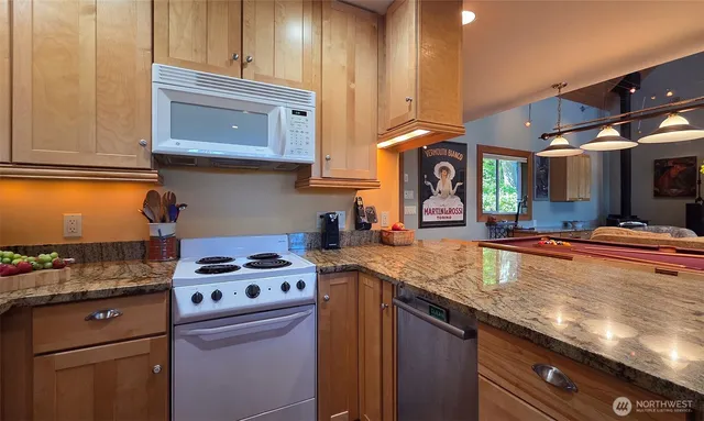 a kitchen with stainless steel appliances granite countertop a stove a sink and a microwave
