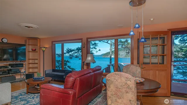 a living room with furniture a flat screen tv and a floor to ceiling window
