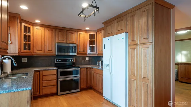 a kitchen with stainless steel appliances granite countertop a refrigerator stove and sink