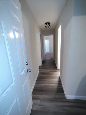 a view of a hallway with wooden floor and entryway
