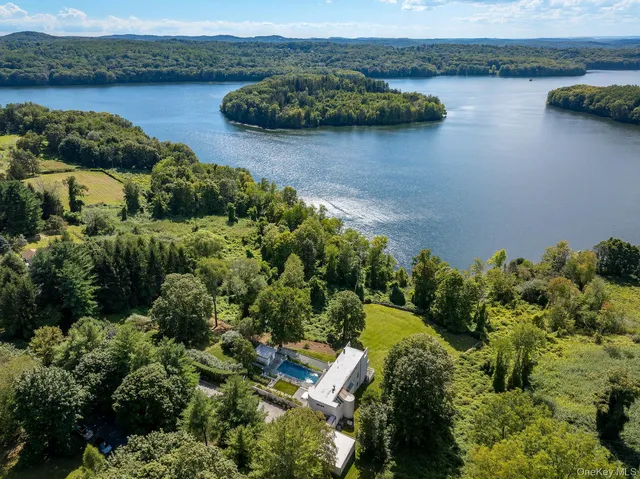 an aerial view of a house with a yard and lake view