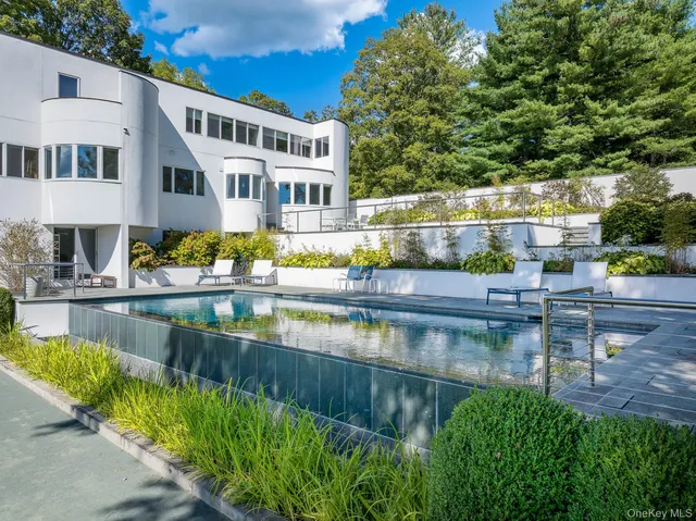 a view of house with swimming pool and outdoor seating