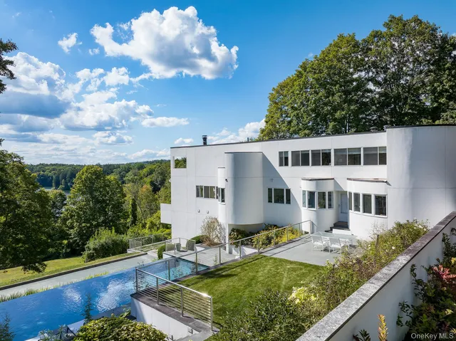 a view of a house with swimming pool and sitting area