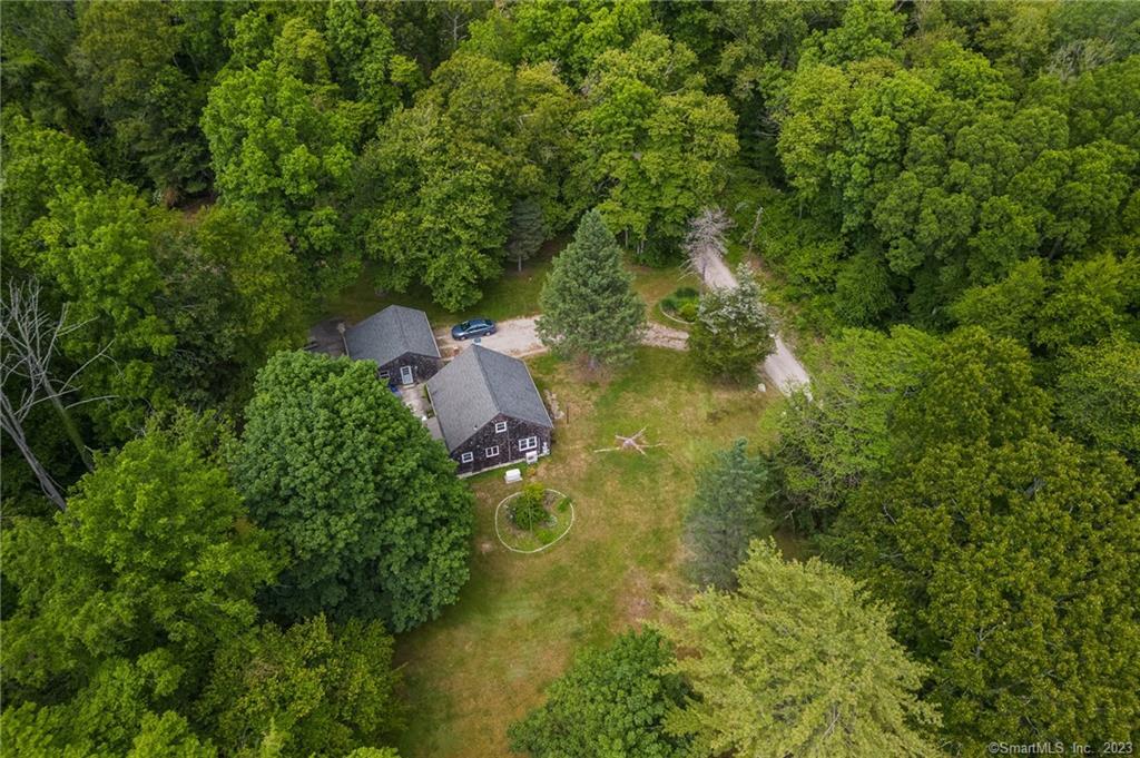 an aerial view of residential house with outdoor space and trees all around