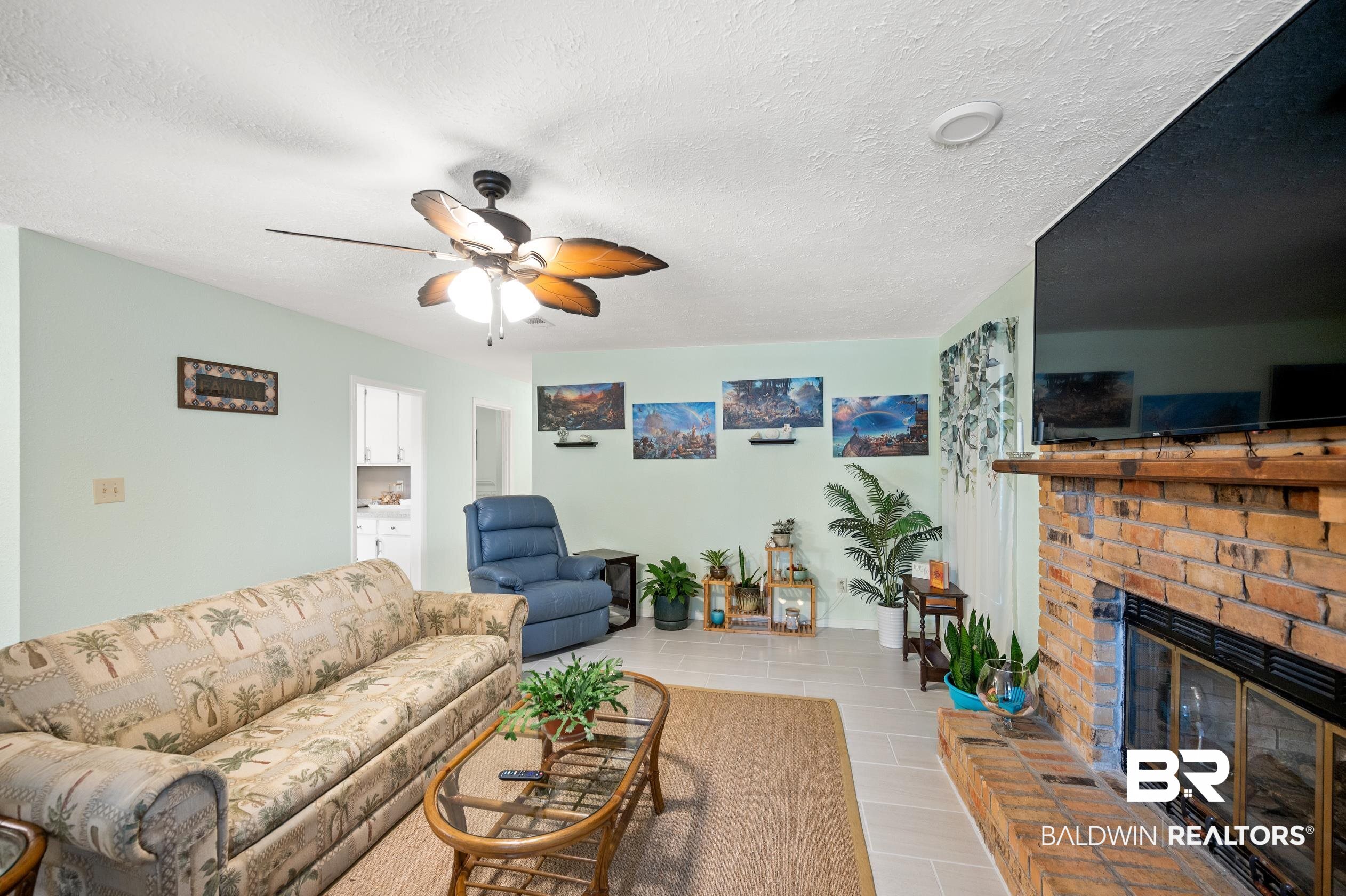2772 Santa Rosa Circle Lillian, AL 36549 - Photo 6 of 50 Tiled living room with a fireplace, a textured ceiling, and ceiling fan