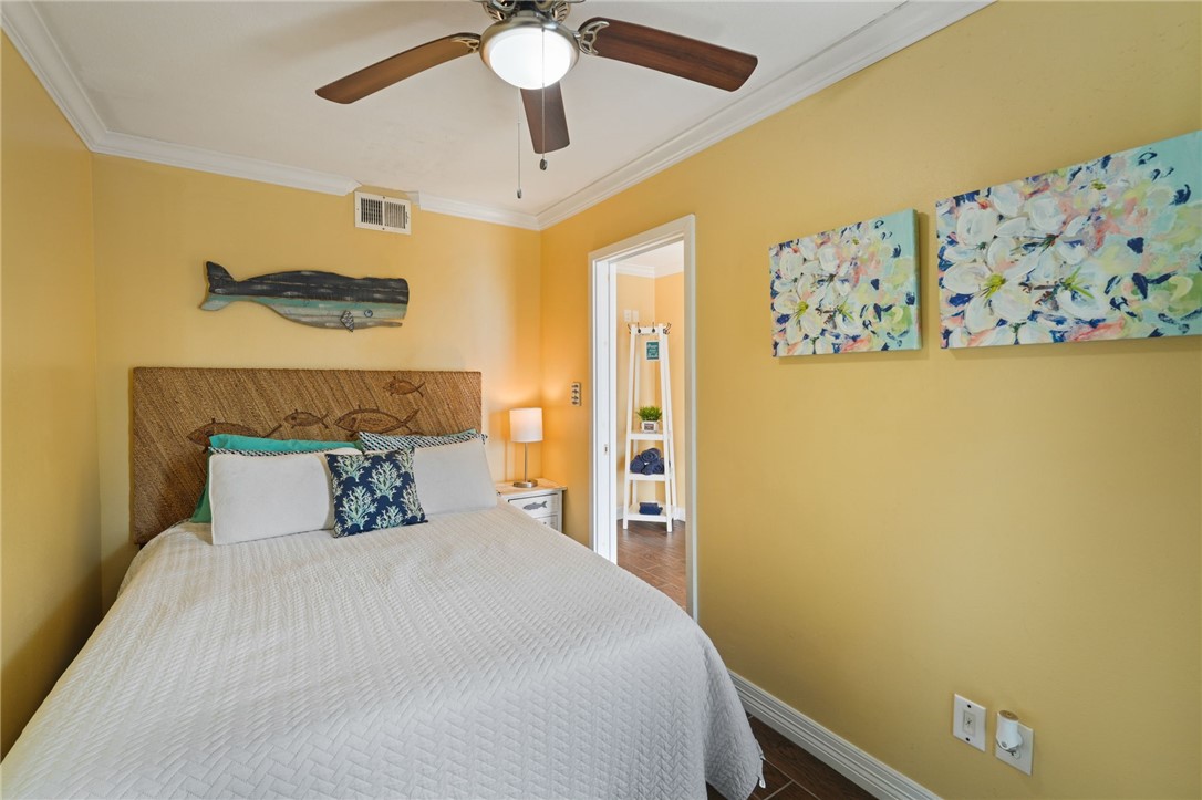 3938 Surfside Boulevard, Unit 1139 Corpus Christi, TX 78402 - Photo 8 of 14 a bedroom with a bed and a painting on the wall