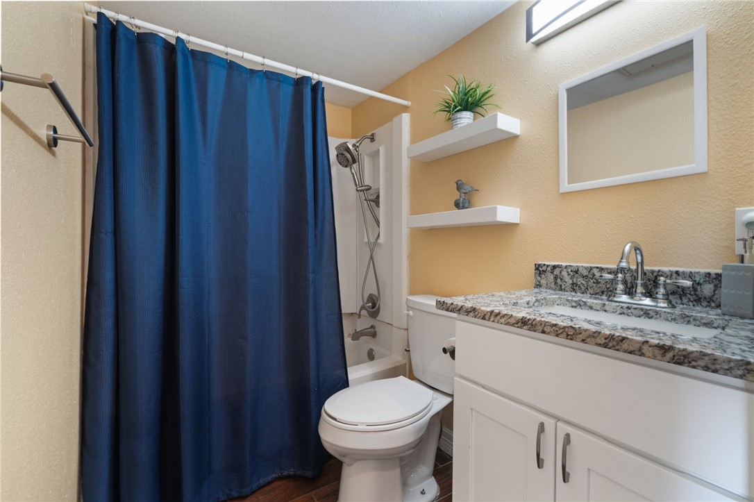 3938 Surfside Boulevard, Unit 1139 Corpus Christi, TX 78402 - Photo 10 of 14 a bathroom with a granite countertop sink toilet and shower