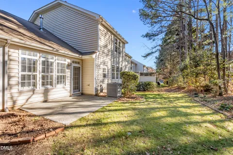 a view of a house with backyard and a tree