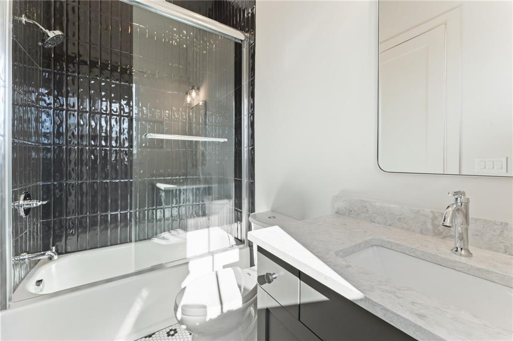 1090 Lupo Loop Chattahoochee Hills, GA 30268 - Photo 22 of 23 a bathroom with a granite countertop sink a mirror and shower