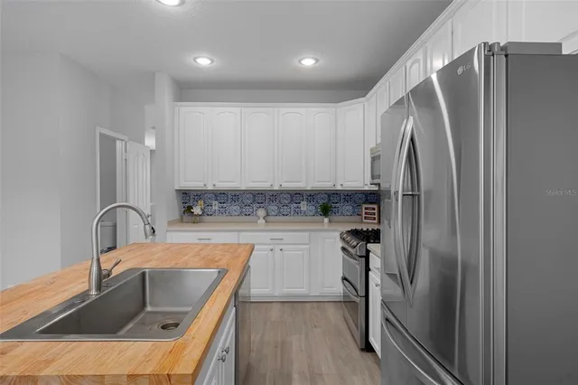 a kitchen with stainless steel appliances a refrigerator and a sink