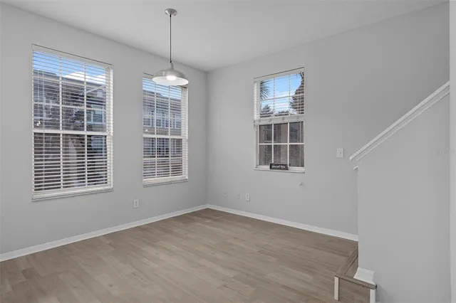 a view of empty room with wooden floor and window
