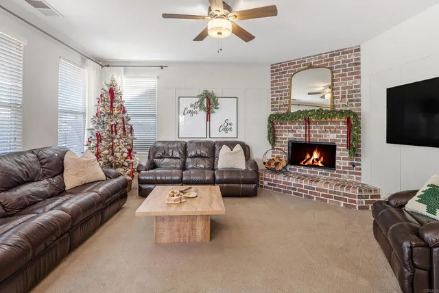 a view of a livingroom with furniture window and a ceiling fan