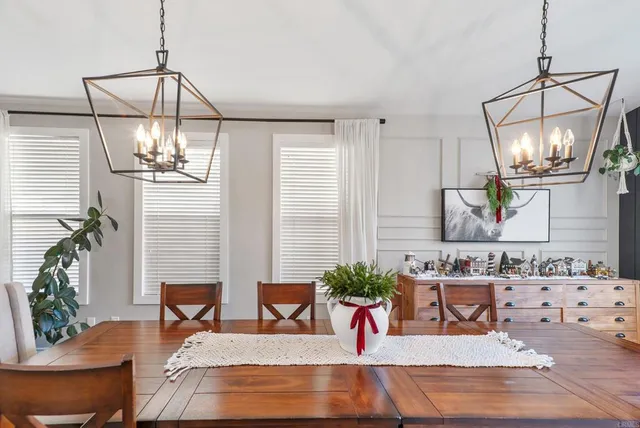 a dining room with wooden floor a chandelier a glass table and chairs