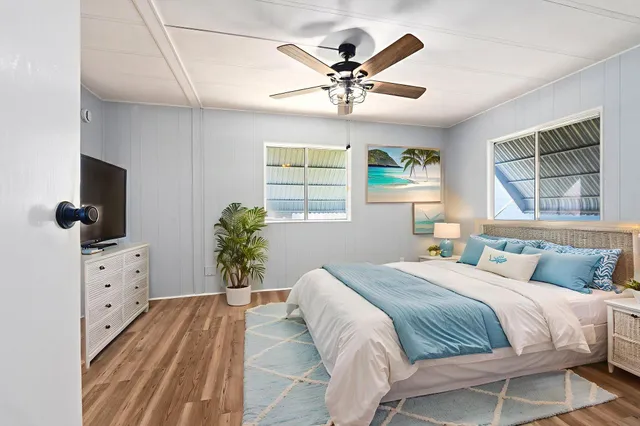 a bedroom with a large bed and a flat tv screen on dresser