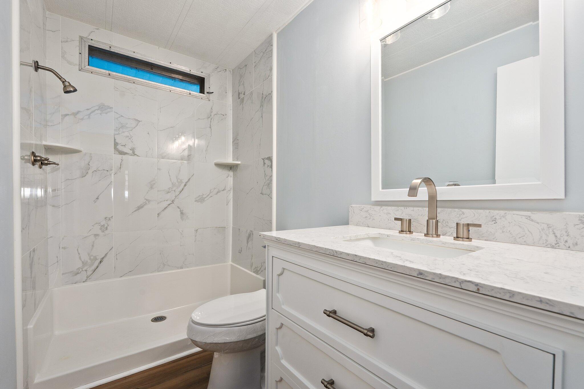 4800 Southeast Federal Highway, Unit 53 Stuart, FL 34997 - Photo 23 of 36 a bathroom with a sink a toilet and shower