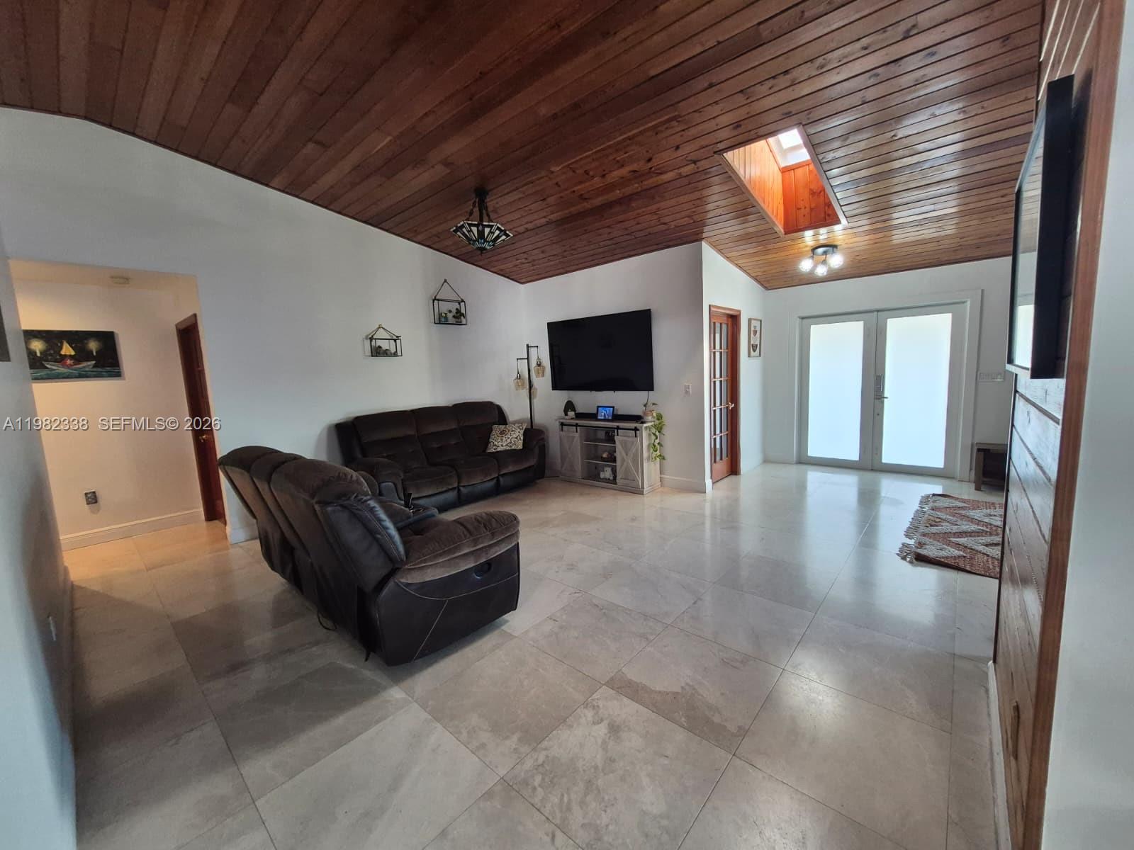 14530 Southwest 110th Street Miami, FL 33186 - Photo 7 of 45 a living room with furniture a flat screen tv and a fireplace