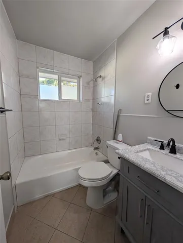 a bathroom with a granite countertop toilet a sink and bathtub