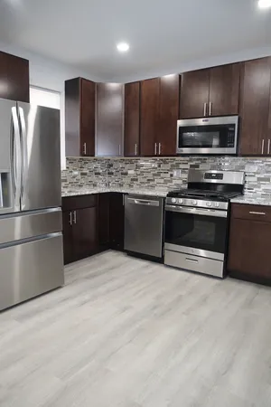 a modern kitchen with stainless steel appliances granite countertop a stove and a refrigerator