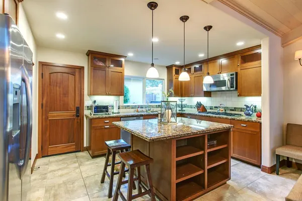 a kitchen with stainless steel appliances granite countertop a stove and refrigerator