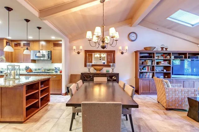 a kitchen with stainless steel appliances wooden floor dining table and chairs