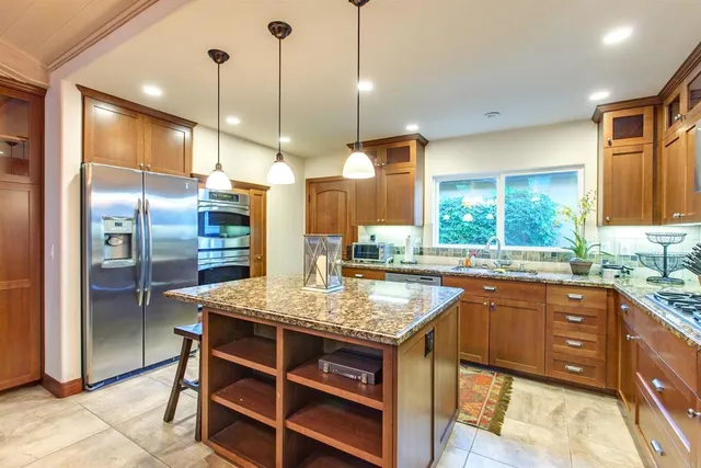 a kitchen with stainless steel appliances granite countertop a sink a stove and a refrigerator