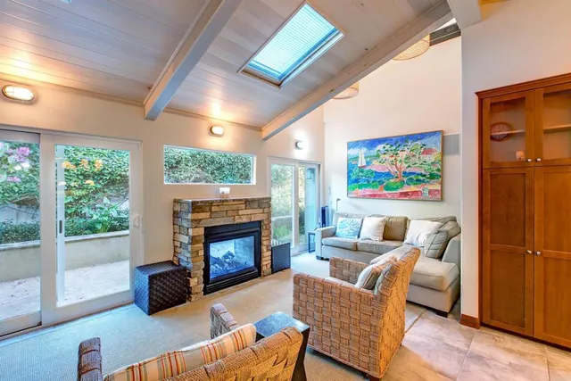 a living room with furniture large window and fireplace