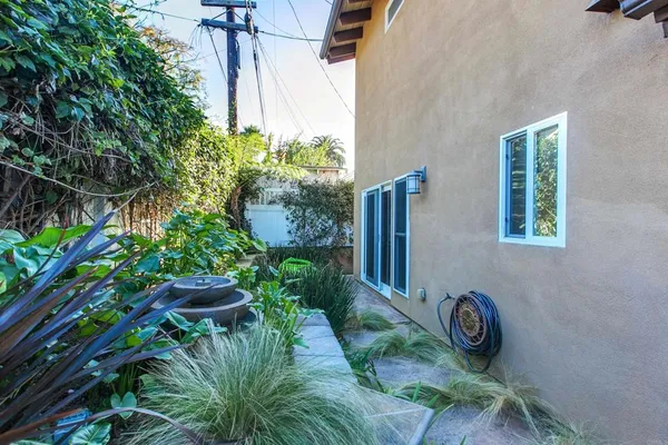 a view of a backyard with plants and a bench