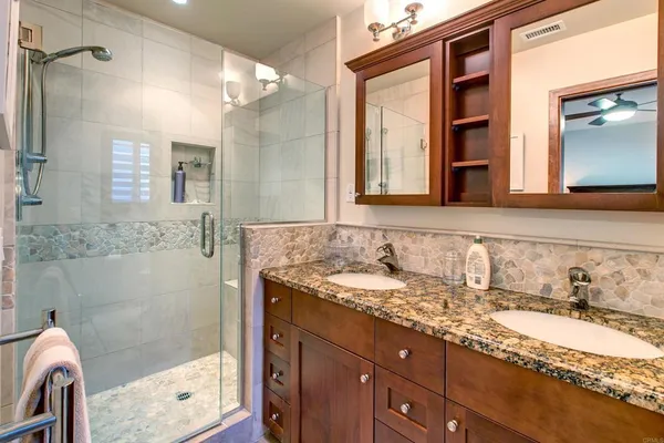 a bathroom with a granite countertop sink mirror and shower