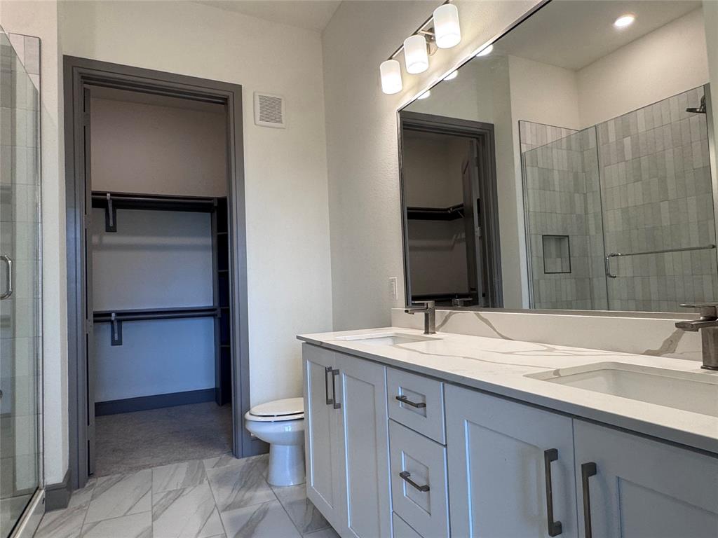 2700 Old Denton Road, Unit 1030 Carrollton, TX 75007 - Photo 13 of 28 a bathroom with a sink a toilet and vanity