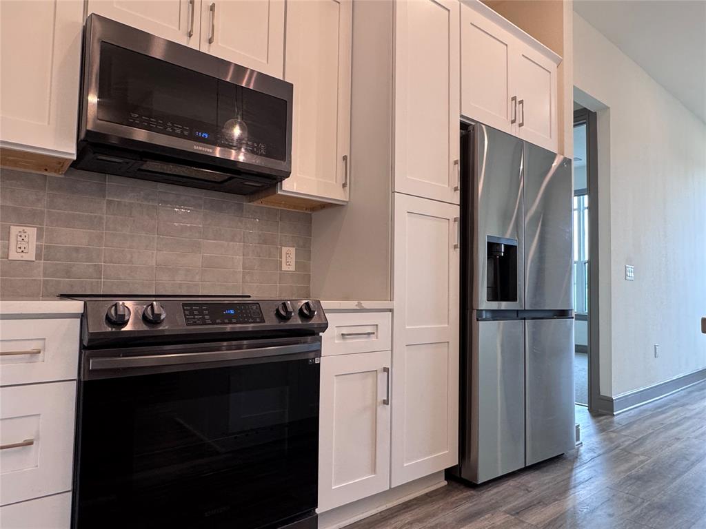 2700 Old Denton Road, Unit 1030 Carrollton, TX 75007 - Photo 6 of 28 a kitchen with stainless steel appliances a stove a microwave and cabinets