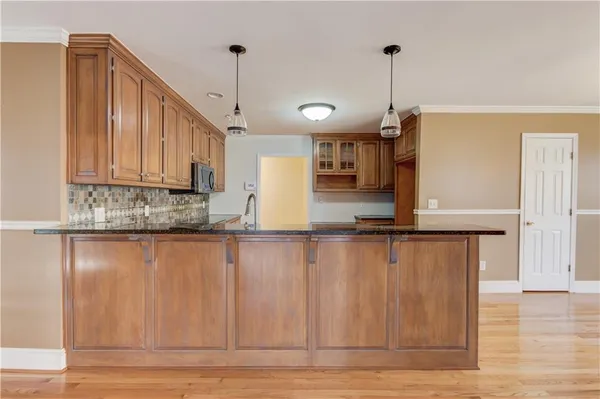 a kitchen with stainless steel appliances granite countertop a sink stove and microwave