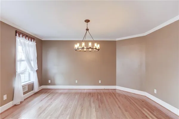 a view of a chandelier in big room and wooden floor